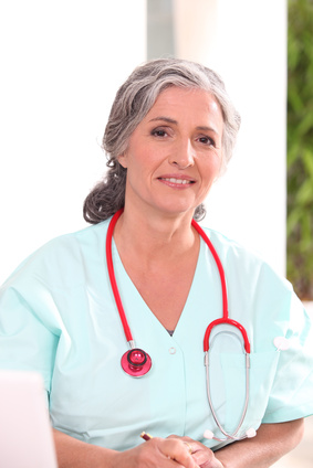 Medic in scrubs working at a desk