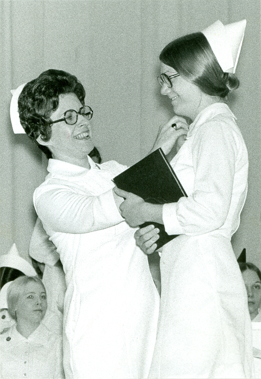 Nurse pinning a graduate at a hospital school of nursing in 1975