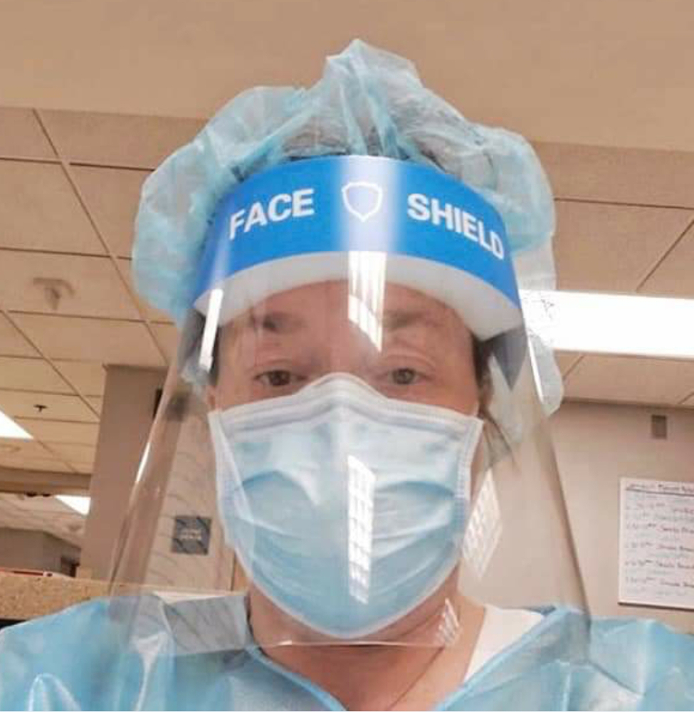 Elizabeth Kemp in a face shield and surgical mask on the hospital floor