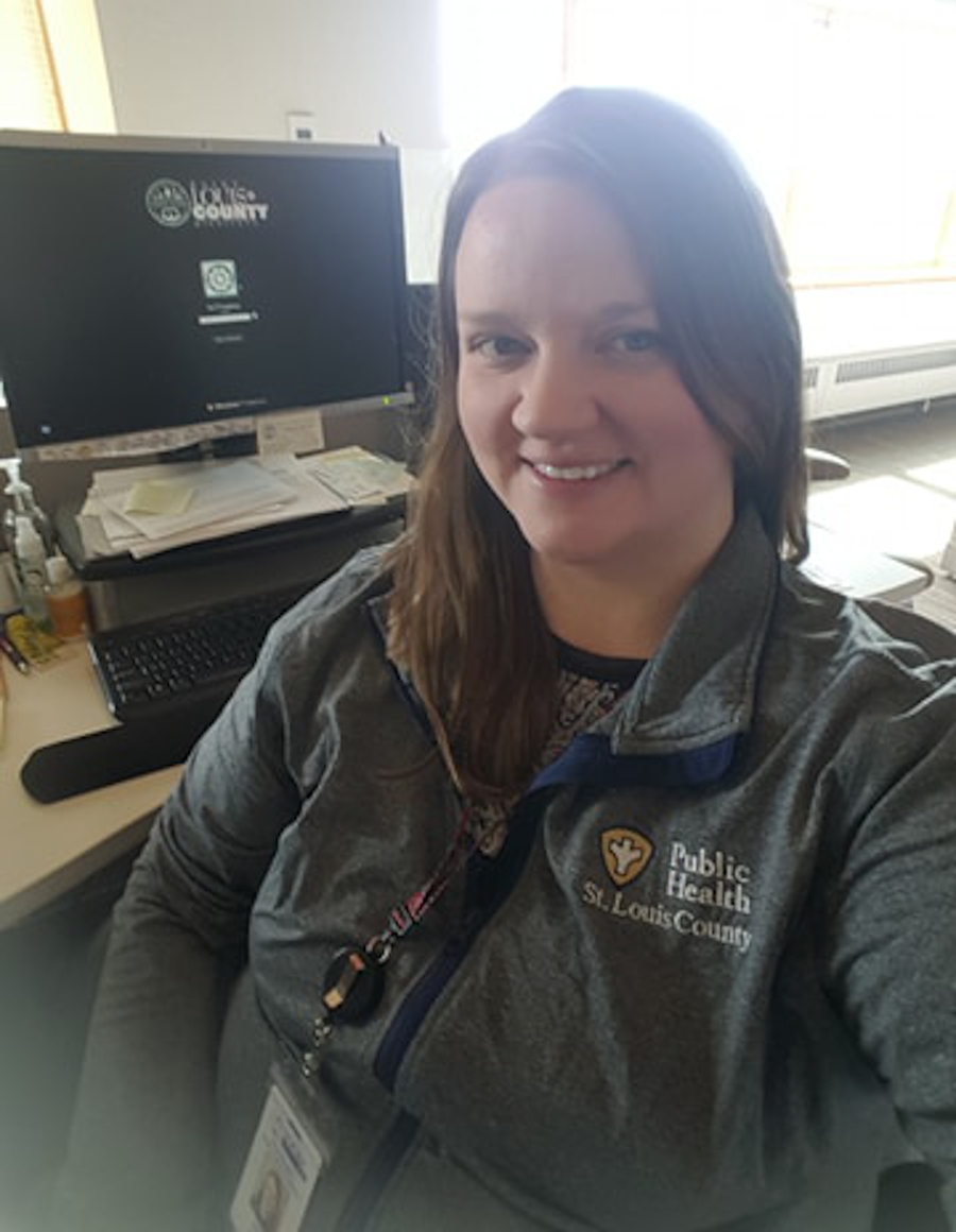 Jody Eaton smiling at her desk beside a computer monitor
