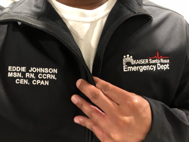 Close-up of a black Emergency Dept jacket embroidered Eddie Johnson MSN, RN, CCRN, CEN, CPAN