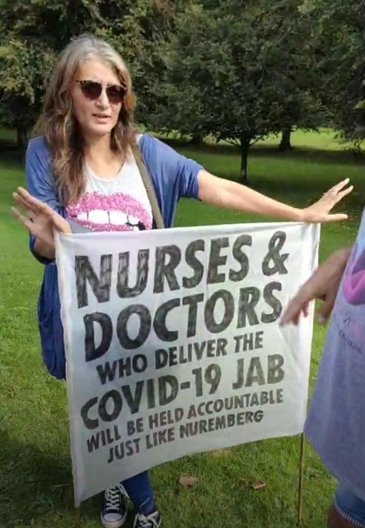 Protester holding a banner saying doctors and nurses giving Covid-19 shots will face Nuremberg