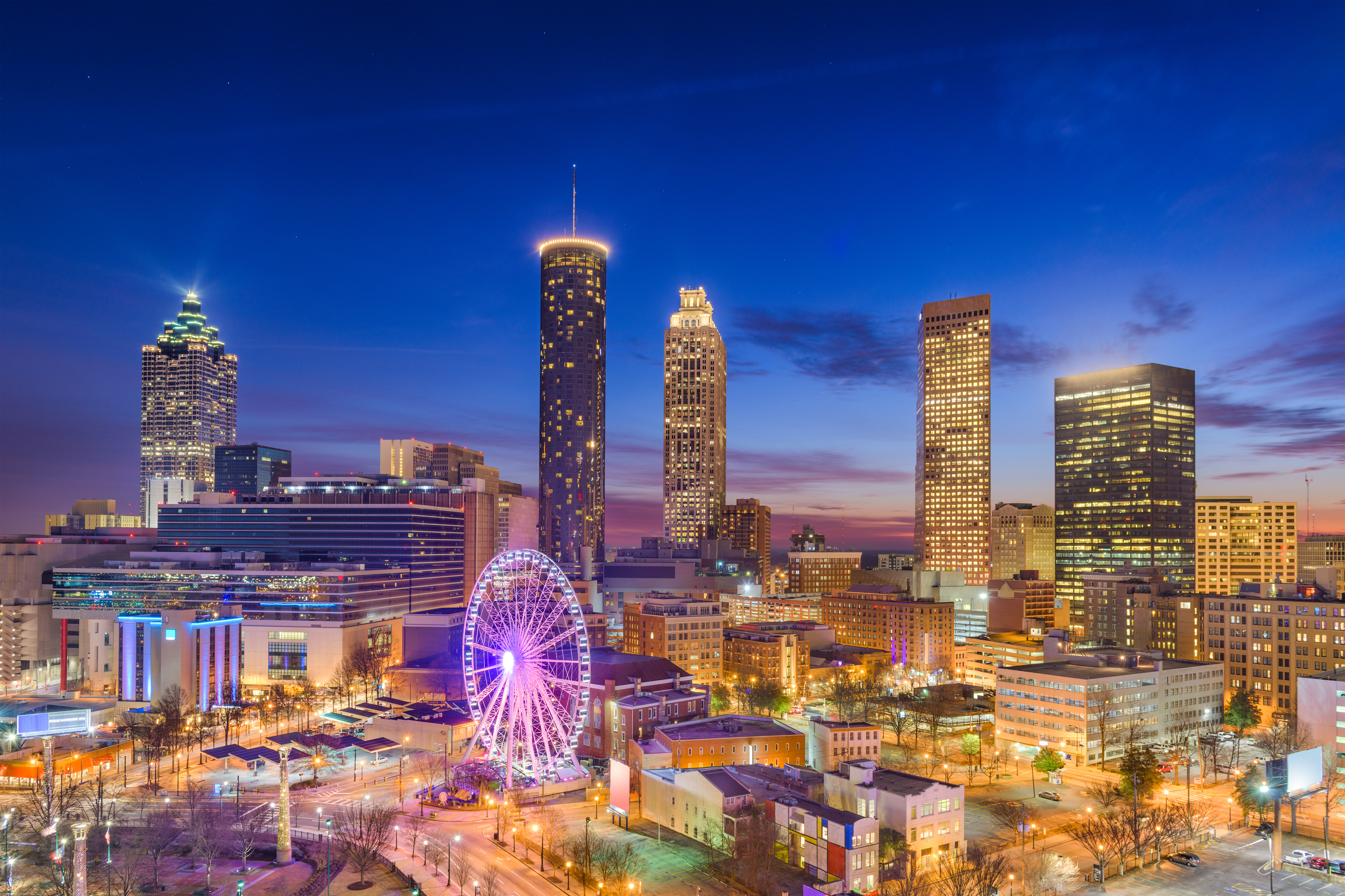 Atlanta skyline at dusk with the SkyView Ferris wheel lit up in purple